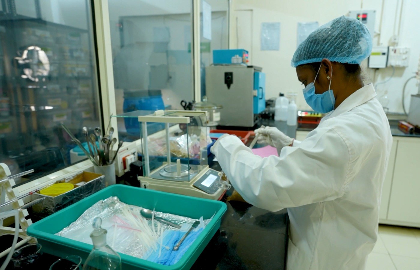Technicienne en blouse préparant un contrôle en laboratoire